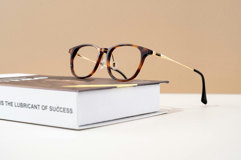 What's VirtuaGro Stylish tortoiseshell eyeglasses resting on a hardcover book with motivational text.